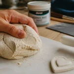 Pâte autodurcissante : main qui malaxe la pâte avant création sans fissures