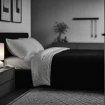 Noir et blanc chambre, lit et tapis clairs, lumière chaude